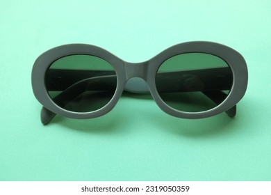 sunglasses round in gray plastic frame isolated on green pastel background.retro fashion bold frame style