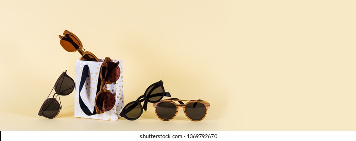 Sunglasses sale. Summer sale-out offer. Sunglasses in wooden frame on yellow background. Copy space for text. For banner optic shop