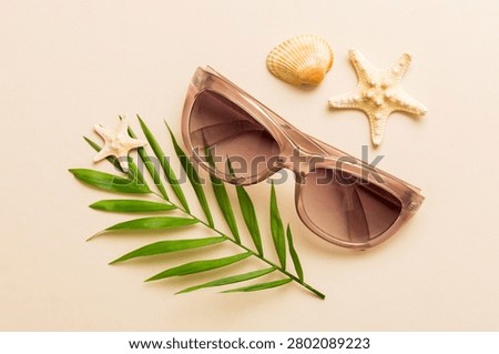 sunglasses with seashell lying on table background. Sunglasses on summer background. Top view flat lay with copy space for text.