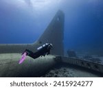 Sunken Military Hercules C-130 off the Red Sea coast in the Gulf of Aqaba, dwarfing a diver