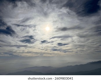 Sunlight breaking through clouds over mountain