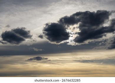 Sunlight breaking through dark clouds. Dramatic sky with sun rays and moody atmosphere.