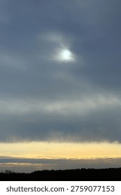 Sunlight Breaking Through Overcast Clouds in a Dramatic Sky with silhouetted forest