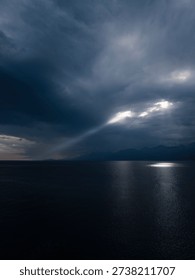 Sunlight breaking through storm clouds on seascape