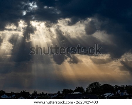 Sunlight breaks through the dark cloudy sky
