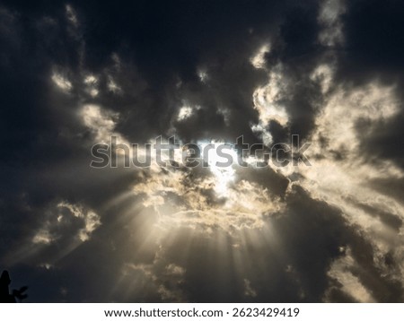 Sunlight breaks through the dark cloudy sky