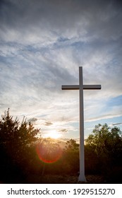 Sunlight bursts behind a mountain top cross of Jesus during golden hour at sunrise on Easter Morning 02