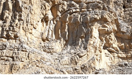 Sunlight casting dramatic shadows across folded rock layers, exposing intricate geological patterns creating mesmerizing textures on rugged cliff surface