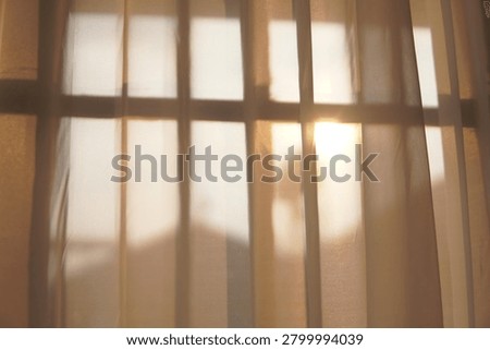 Sunlight casting shadows through window bars onto a wall
