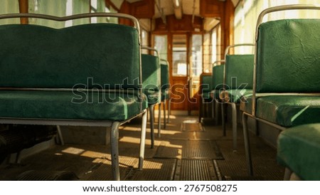 Sunlight casts long shadows across the worn floor and green vinyl seats inside an old-fashioned tramcar