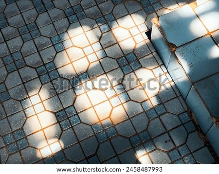Sunlight casts patterns on hexagonal floor tiles, highlighting their texture and color