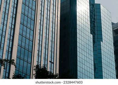 Sunlight and clouds reflected on the walls of modern buildings made of glass and steel