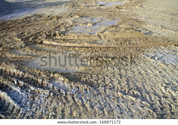 sunlight\
construction soil with tractor wheel trace\
