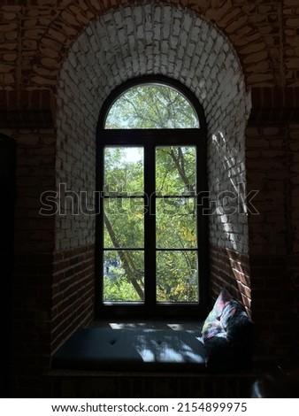 Sunlight is entering dark room through arch shaped windows