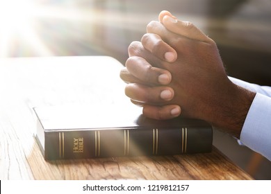 Sunlight Falling On Man's Hand Over Holy Bible Book