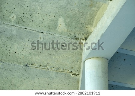Sunlight highlights the rough surface and sharp angles of a concrete structure.