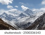 Sunlight illuminating the snow-capped peak of mount manaslu and surrounding mountains, casting shadows over the valleys below in the nepalese himalayas