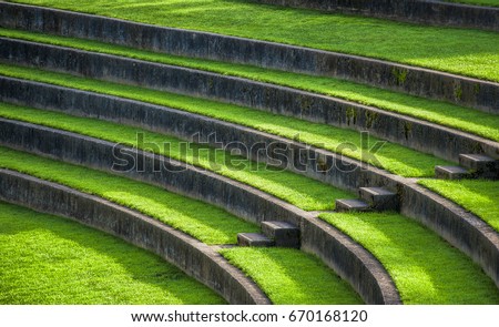 Sunlight leads the eye down the steps of the outdoor grass seating in the Rose Gardens Amphitheater, at Washington Park in Portland, Oregon