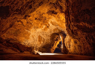 Sunlight in a mountain cave. Mountain cave tunnel. Beautiful sunlight in cave. Cave hole landscape