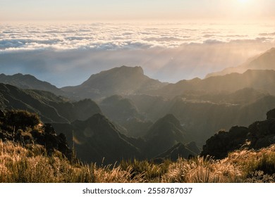sunlight over a mountain range which is above the clouds during sunrise