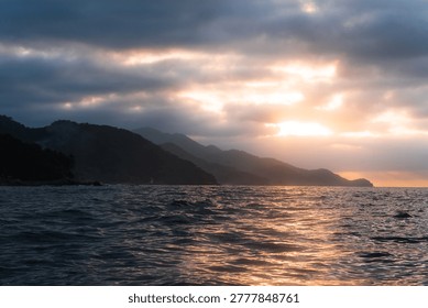 Sunlight peeking through clouds over the ocean