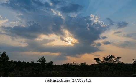 Sunlight peeking through the clouds; sunset.