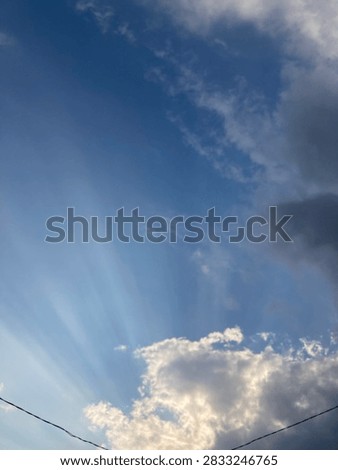 Sunlight pierces through the bright clouds