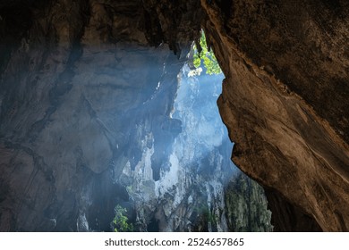 Sunlight piercing through Batu cave entrance, illuminating the rugged rock formations and casting a mystical glow, creating a serene and mysterious atmosphere, Kuala Lumpur, Malaysia. Hindu landmark - Powered by Shutterstock