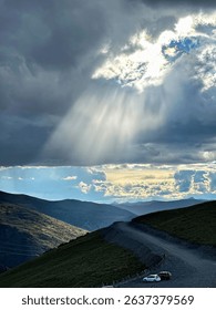 Sunlight Piercing Through Clouds Over Mountain Top (Crepuscular Rays)