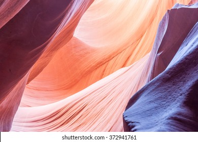 Sunlight plays deep into Lower Antelope Canyon creating the amazing colors purple pink orange and patterns the light reflecting on silica rich limestone surface  Page Arizona USA - Powered by Shutterstock