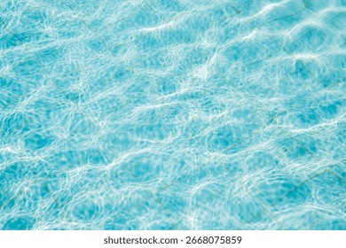Sunlight reflecting and creating beautiful patterns on the turquoise water surface of a swimming pool, ideal for summer and travel backgrounds