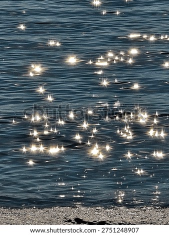 The sunlight reflecting off the waves creates a shimmering, star-like effect in the sea.
