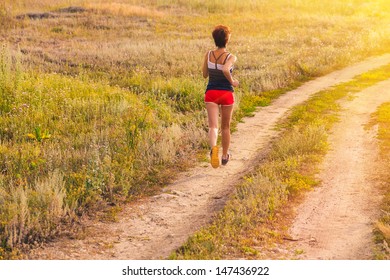 sunlight road beautiful healthy brunette young woman athlete running outdoors, fitness and healthy lifestyle, running