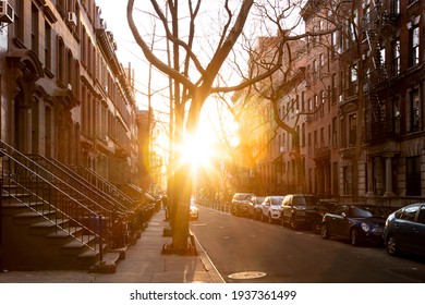 Sunlight shines on a block of historic brownstone buildings on Perry Street in the West Village neighborhood of New York City NYC