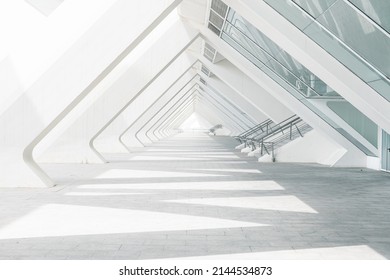 The sunlight shines through columns in a long and white corridor - Shutterstock ID 2144534873