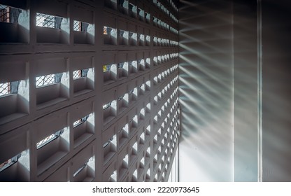 The Sunlight Shines Through Light Channels Wall Of Old Gymnasium. Concrete Walls Have Holes For Sunlight To Penetrate Through The Holes From The Outside, Light And Shadow Concept, Selective Focus.