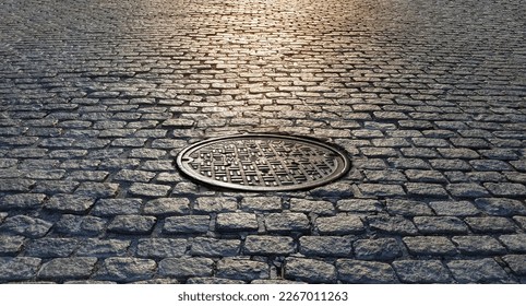 Sunlight shining on a manhole cover in an old cobblestone street in New York City NYC