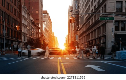 Sunlight shining on the people and cars at a busy intersection on 5th Avenue in Manhattan, New York City