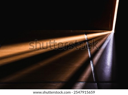 Sunlight shining through a small gap between the door in the wall, creating a pattern on the floor.