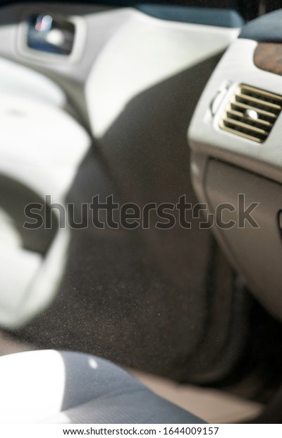 sunlight shows dust floating in the\
air inside the car - unhealthy condition - pollution\
concept