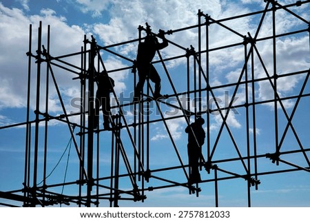 Sunlight silhouettes three construction workers as they balance on the pipes while working in Mexico City, Mexico.                               