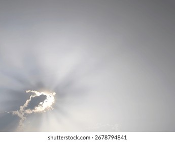 Sunlight streaming through clouds in a bright sky
