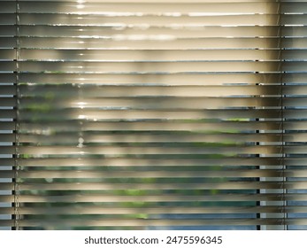 sunlight streaming through a set of horizontal blinds - Powered by Shutterstock