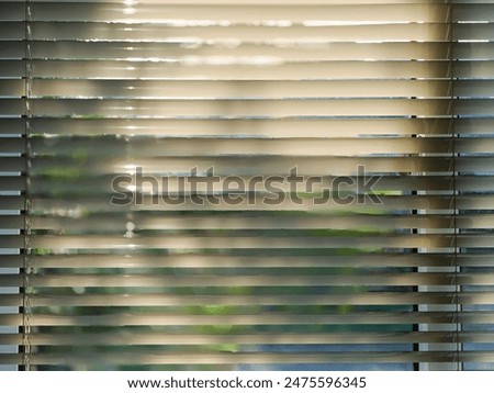 sunlight streaming through a set of horizontal blinds