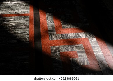 Sunlight streams across patterned marble floor tiles in geometric design.