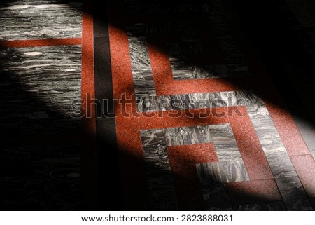 Sunlight streams across patterned marble floor tiles in geometric design.
