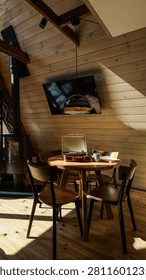 Sunlight streams into a rustic cabin, illuminating a round wooden table set with a portable record player, mug, and book