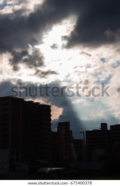 Sunlight\
through the cloud to the building divided the sky into bright side\
and dark side over the sky of Yamaguchi\
City.