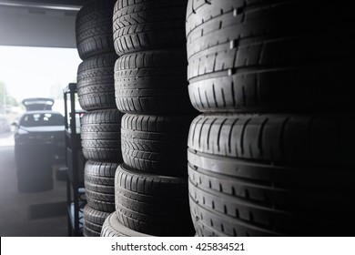 Sunlight In The Tire Storage. Stack Of Old Tires In A Car Shop Garage. Tire Installation Service.