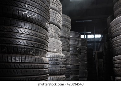 Sunlight In The Tire Storage. Stack Of Old Tires In A Car Shop Garage. Tire Installation Service.